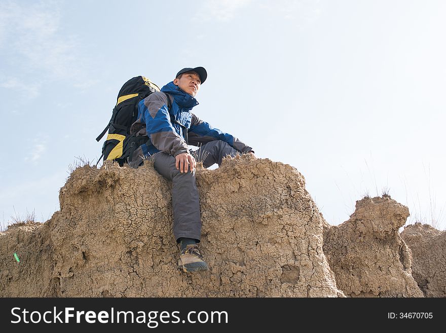 Sitting on a cliff resting hikers. Asian Youth. Sitting on a cliff resting hikers. Asian Youth