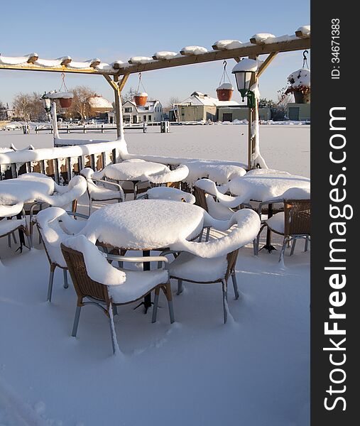 Snow covered furniture of a bar in the winter. Snow covered furniture of a bar in the winter