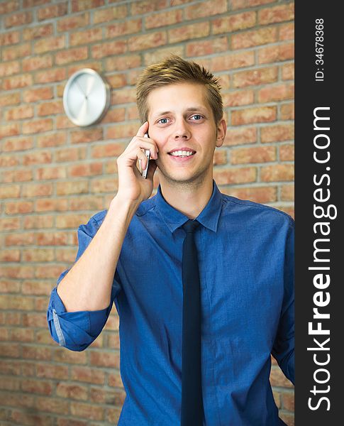 Young businessman talking on phone. Time concept in business