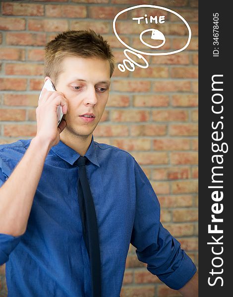 Young businessman talking on phone. Time concept in business