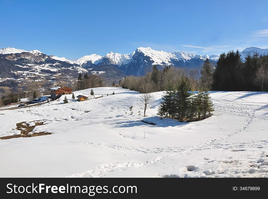 Winter landscape with snowy mountains in background