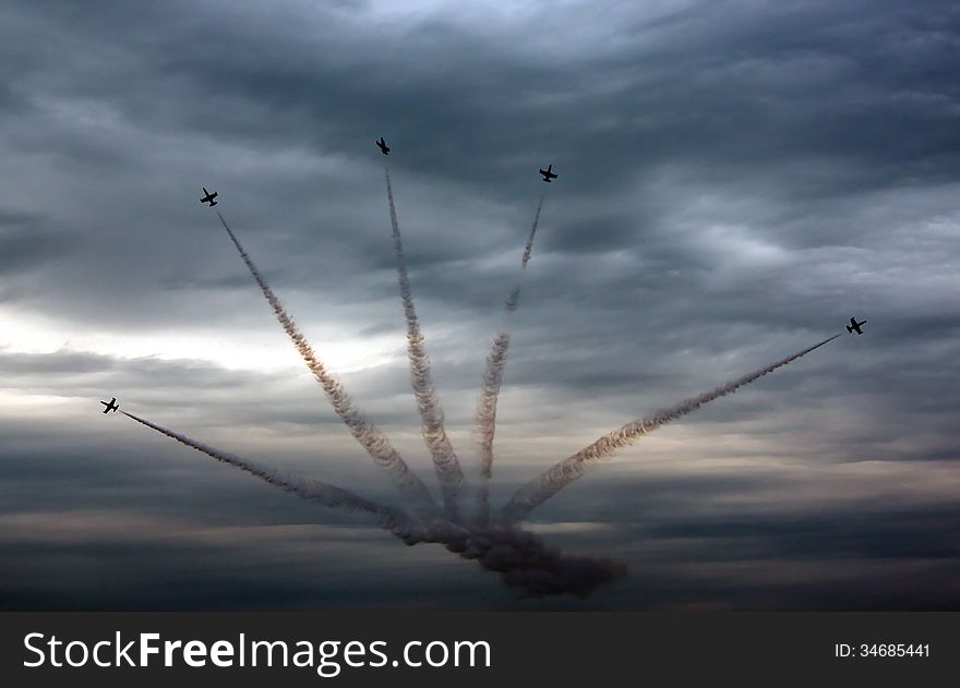 Aviation sports. five aircraft simultaneously fly against the stormy sky tightened with dark clouds. Aviation sports. five aircraft simultaneously fly against the stormy sky tightened with dark clouds