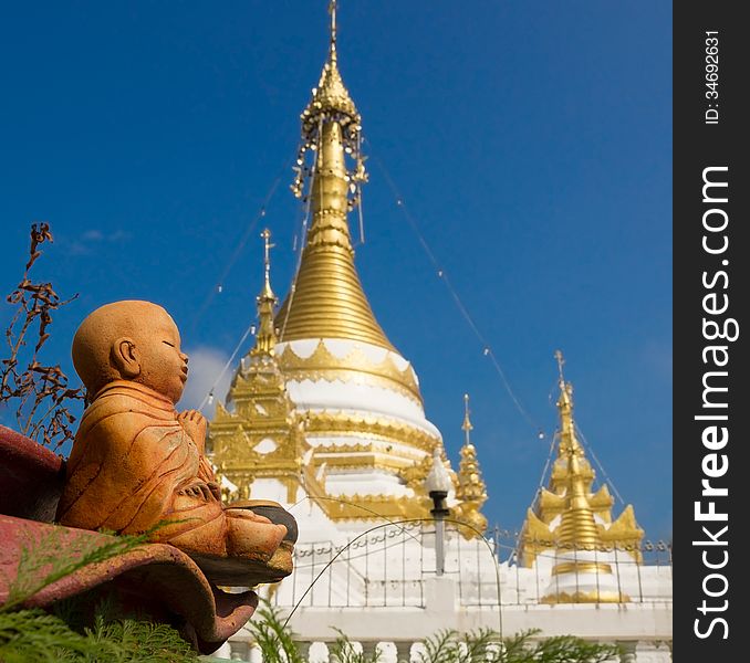 Baby Buddha statue against the Thailand Gold Stupa. Baby Buddha statue against the Thailand Gold Stupa