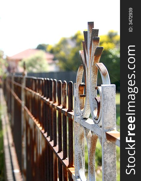 White metal fence with large sections of rust. White metal fence with large sections of rust