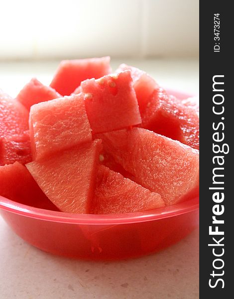 Red bowl filled with cubed watermelon pieces