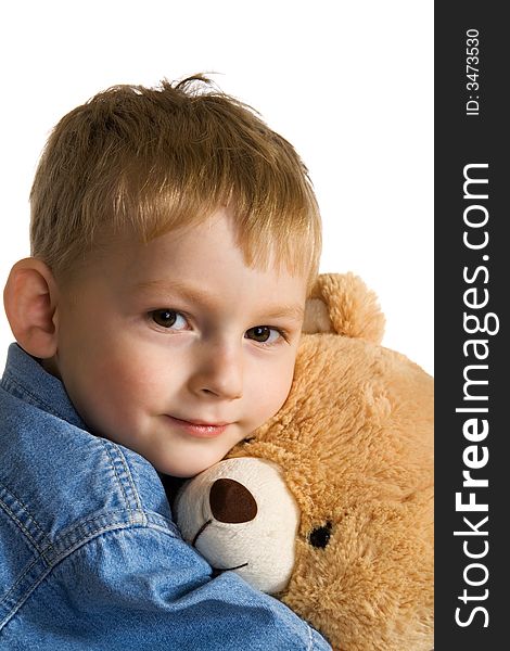The little boy embraces a teddy bear
