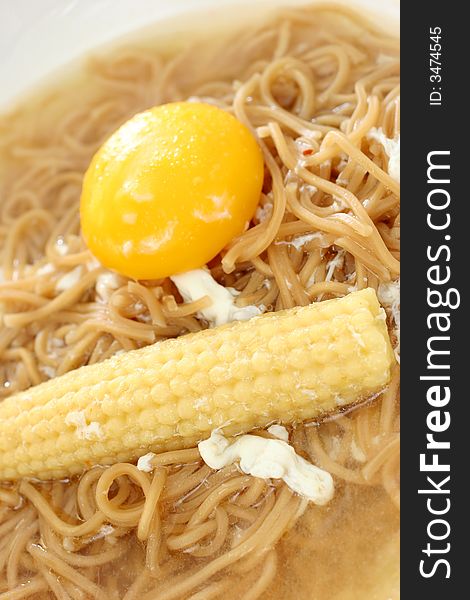 Brown Chinese buckwheat noodles with egg and baby corn in light soup