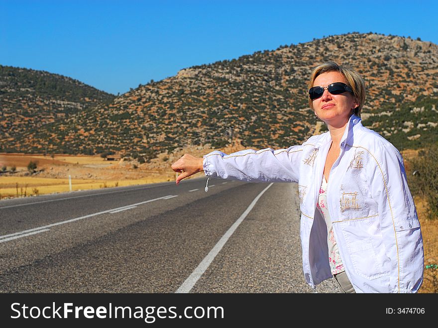 The girl catches machine on road to a background of mountains. The girl catches machine on road to a background of mountains