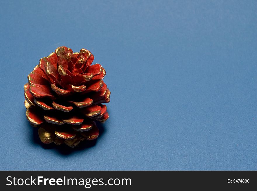 Abstract christmas decoration with Red christmas pine cone isolated on blue background. Abstract christmas decoration with Red christmas pine cone isolated on blue background