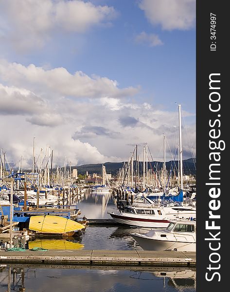 A small yellow boat between slips in a yacht marina