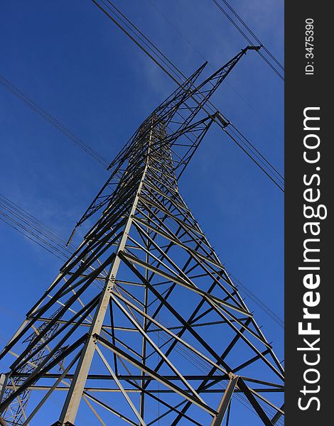 Looking skyward along a high tension tower  while power lines cross the vertical axis. Looking skyward along a high tension tower  while power lines cross the vertical axis
