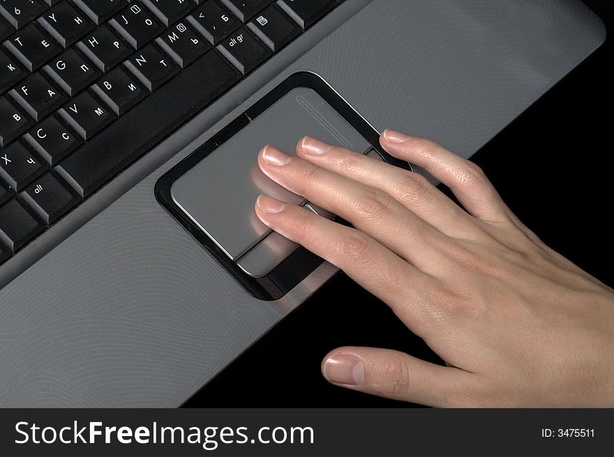 Hand over laptop on black background