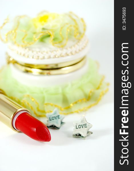 Green decoration box, red lipstick and hair pins with word love written. Green decoration box, red lipstick and hair pins with word love written