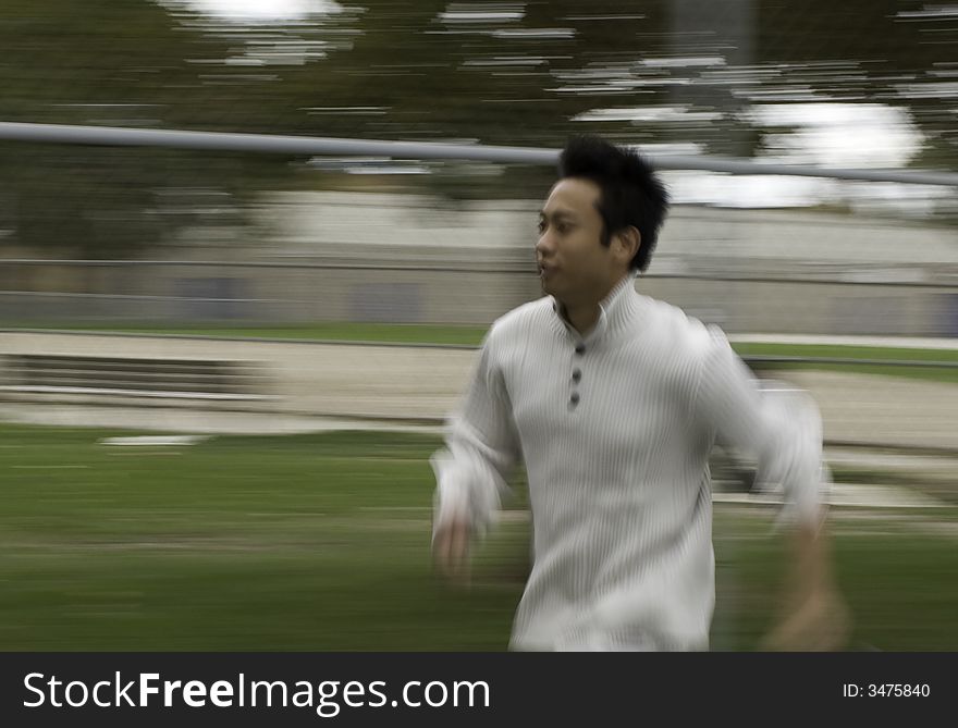 A boy running in tennis court wearing sports clothing. A boy running in tennis court wearing sports clothing