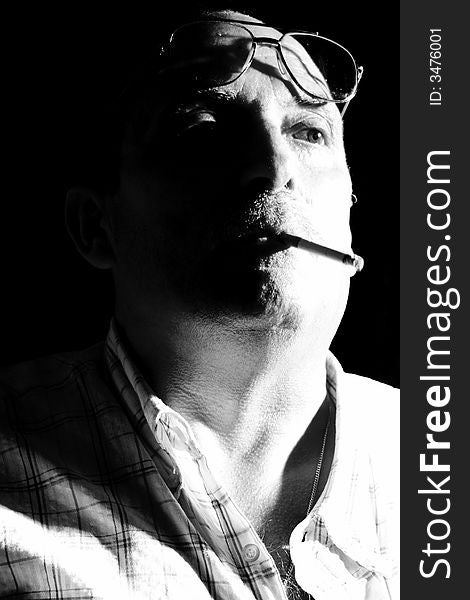 Adult man with glasses takes a cigarette in mouth / Old Suggestive Black and White. Adult man with glasses takes a cigarette in mouth / Old Suggestive Black and White