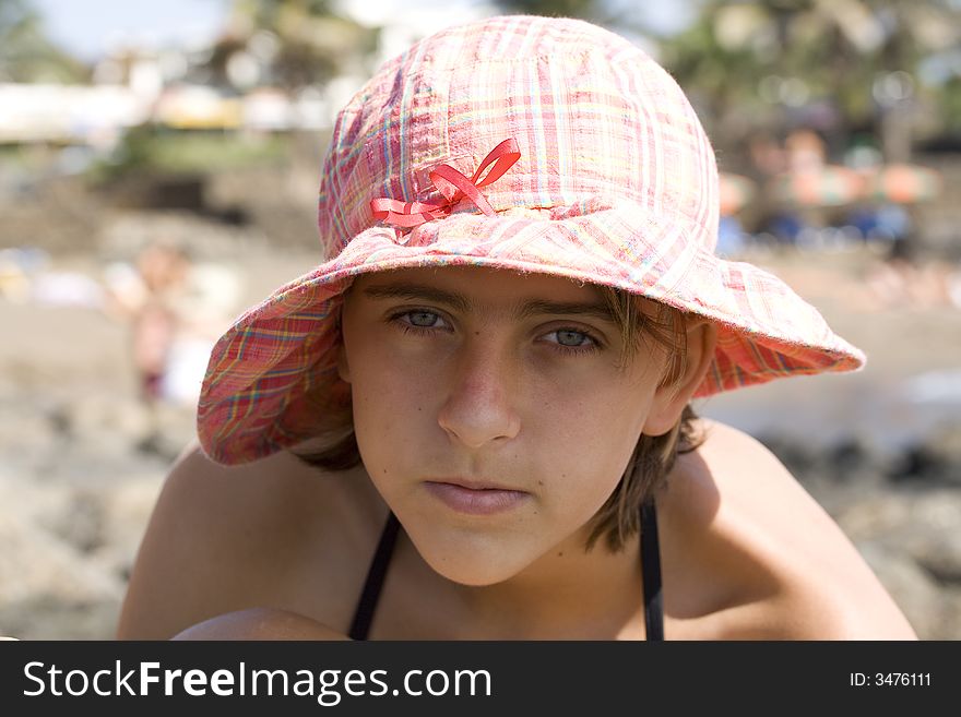 Teenage girl in the hat on the beach