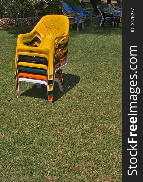 Bright multi-coloured chairs on a lawn near pool. Bright multi-coloured chairs on a lawn near pool
