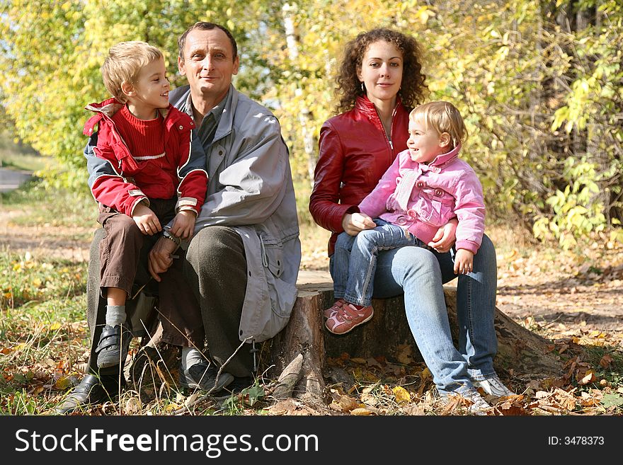 Mother with the daughter and the grandfather they sit in the park in autumn. Mother with the daughter and the grandfather they sit in the park in autumn