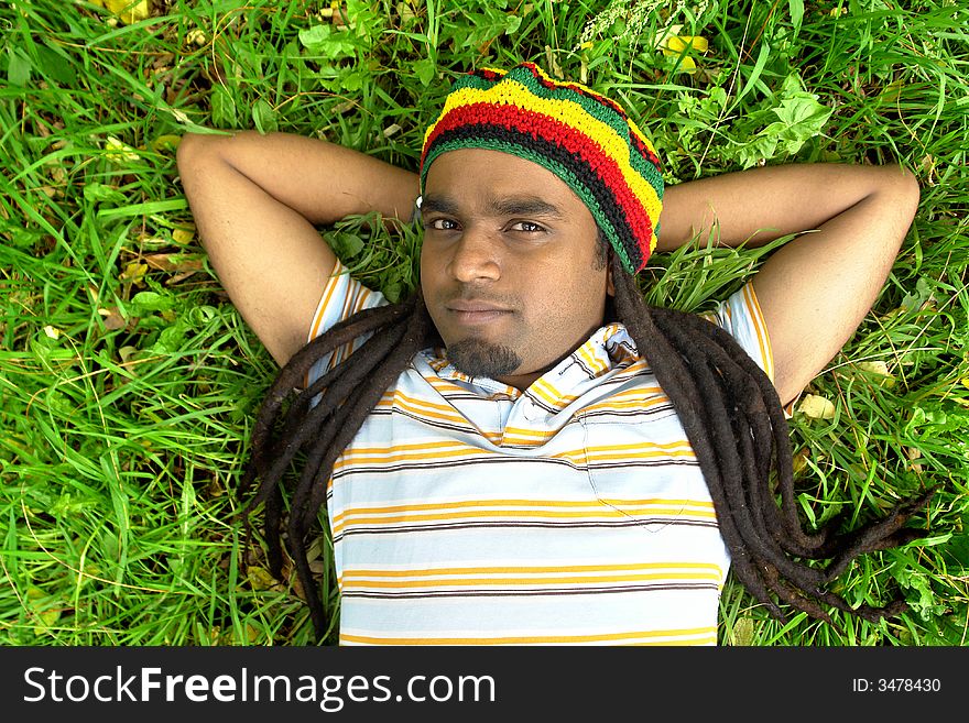 Happy Rastafarian Jamaican laid on grass. Happy Rastafarian Jamaican laid on grass