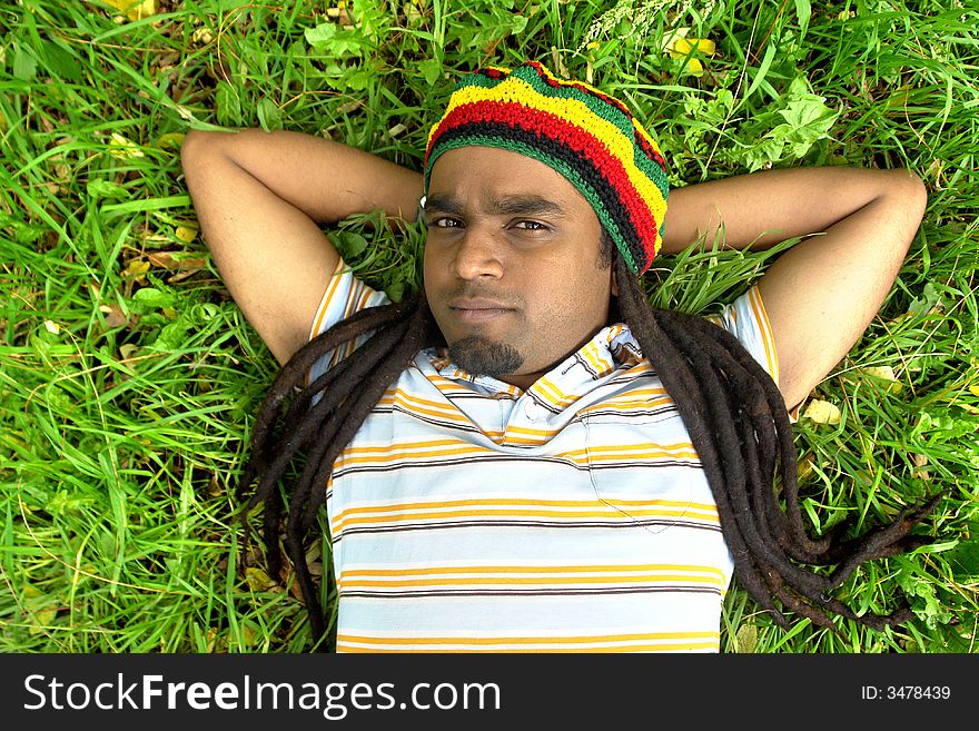 Upset Rastafarian Jamaican laid on grass. Upset Rastafarian Jamaican laid on grass