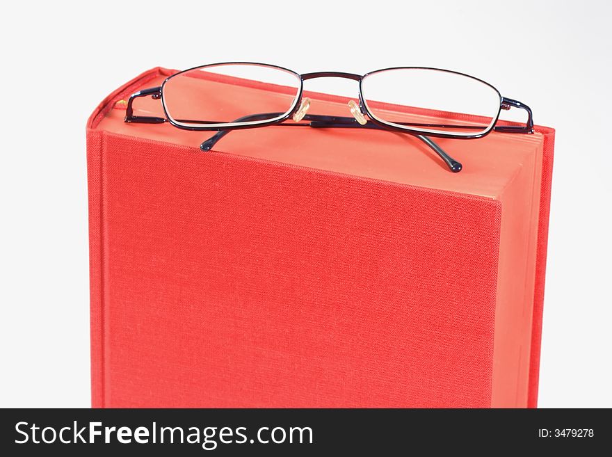 Red book with eye glasses,  isolated with white background. Red book with eye glasses,  isolated with white background