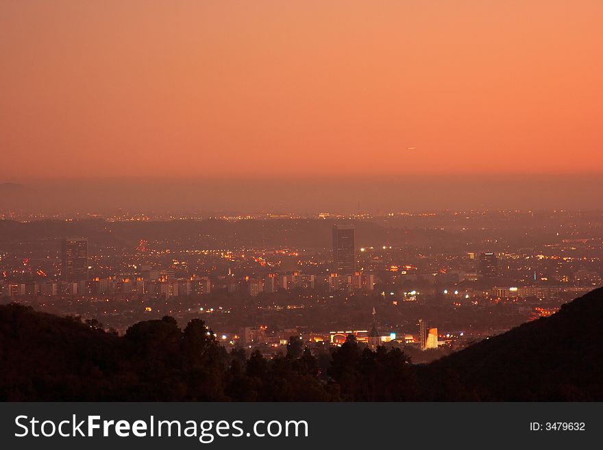 View of downtown Los Angeles and surrounding area during a beautiful orange glowing sunset. View of downtown Los Angeles and surrounding area during a beautiful orange glowing sunset.