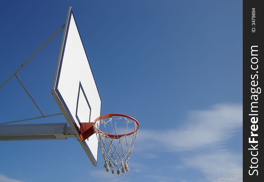 New basketball hoop against blue sky