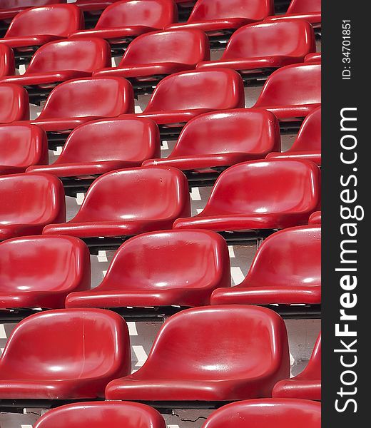 Pattern of empty red stadium seats in sunlight. Pattern of empty red stadium seats in sunlight