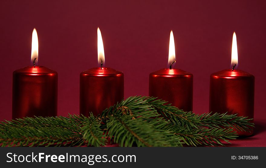 Four burning red candles on the red background