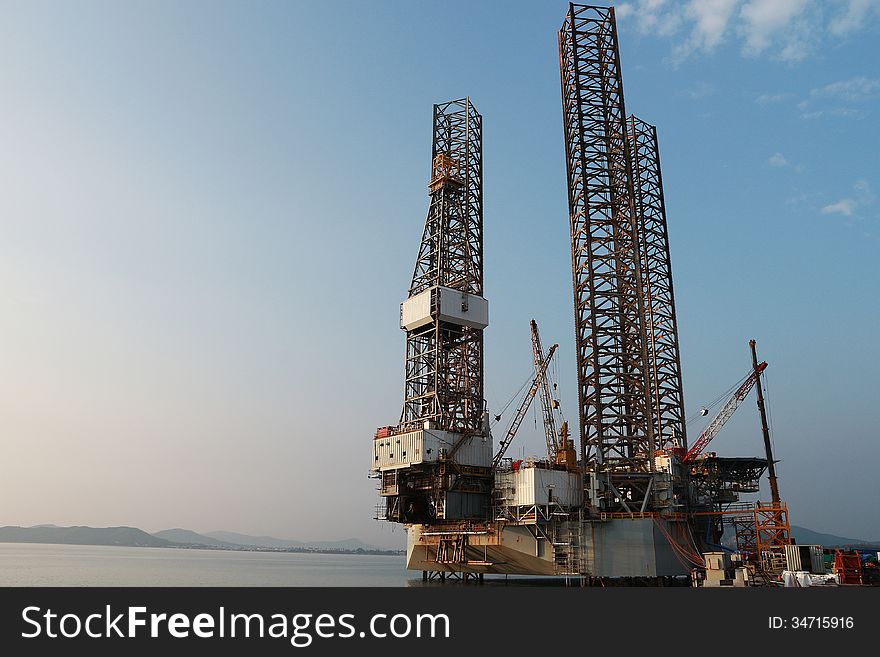 Jack up oil drilling rig in the shipyard at evening time