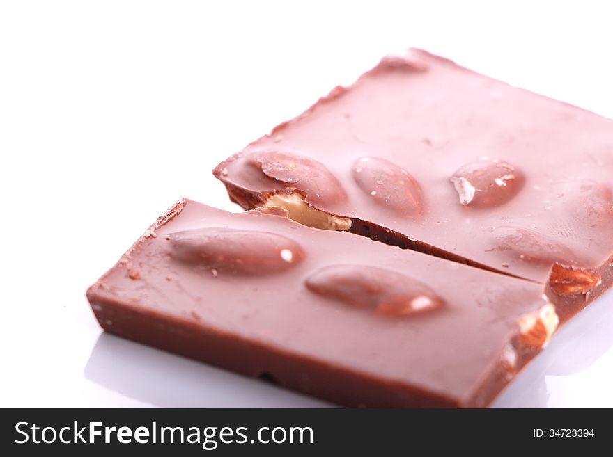 A piece of chocolate with nuts, on white background.