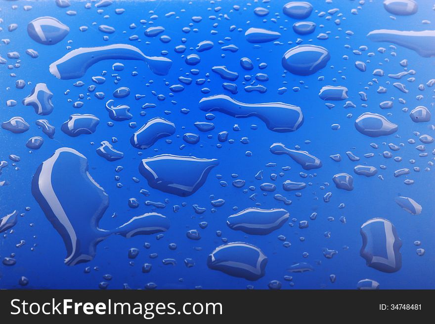 Close up image of water drops on blue surface. Close up image of water drops on blue surface