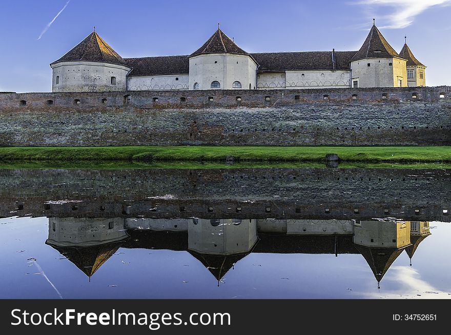 Sunset over the fortress of Fagaras and the swamp surrounding it. Sunset over the fortress of Fagaras and the swamp surrounding it