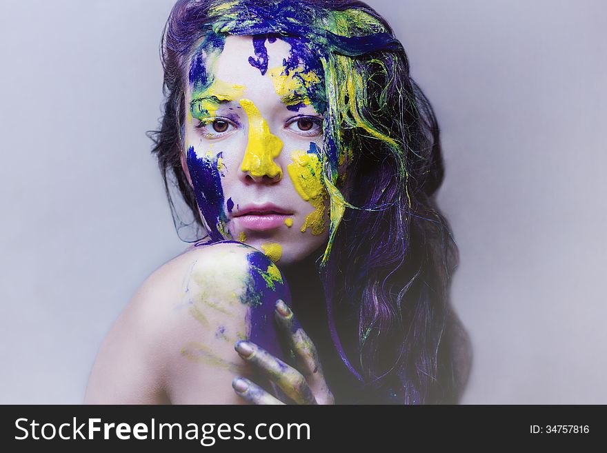 Beauty portrait of a girl painted blue and yellow