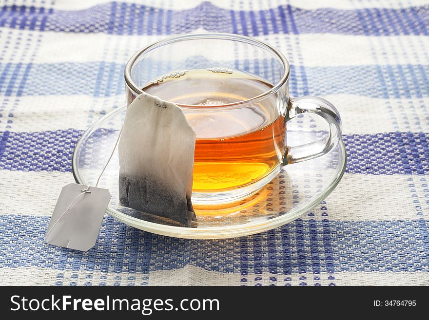 Tea in glass cup, at blue napkin