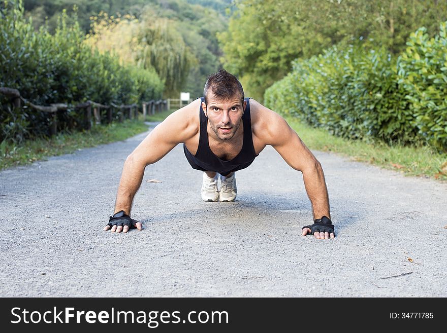 Muscular Man Doing Pushup In The Park.