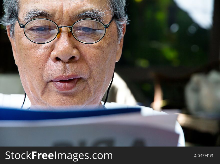 Senior Man Relaxing At Home Reading A Book