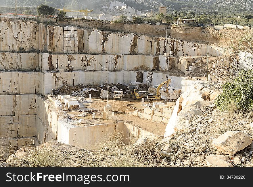 White marble quarry in Sardinia with vehicles maneuvering.