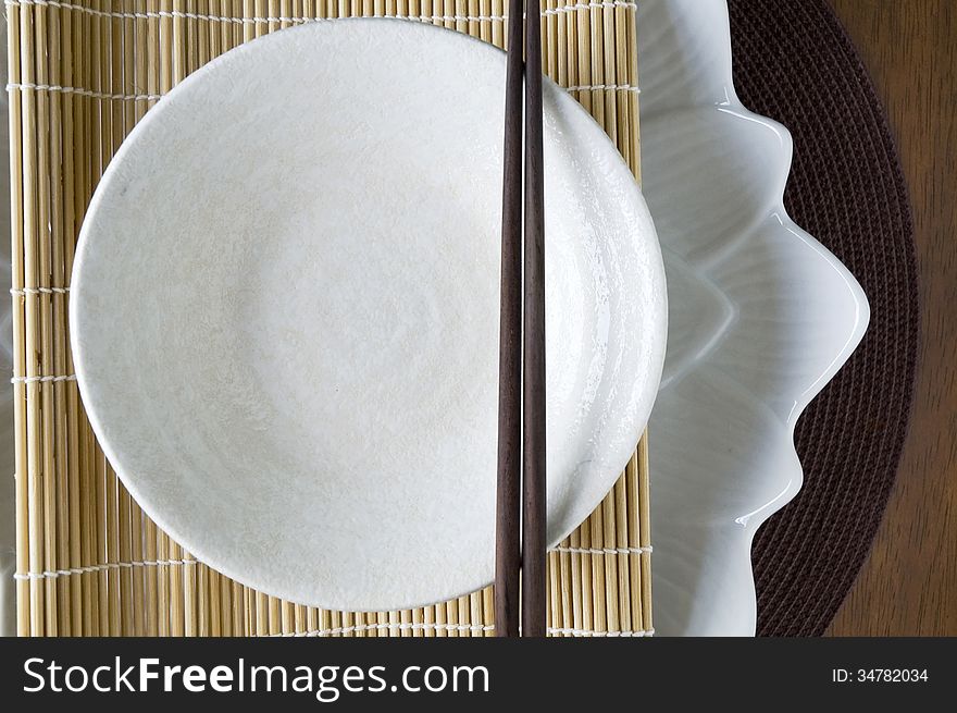 White plate and wooden chopstick in japanese style. White plate and wooden chopstick in japanese style