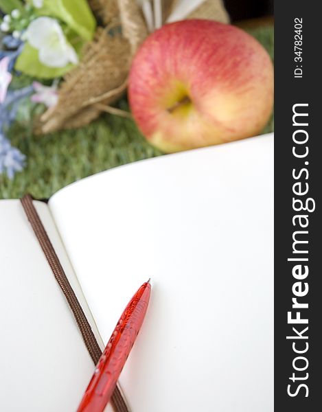 Blank white page with bouquet and fresh apple on grass. Blank white page with bouquet and fresh apple on grass