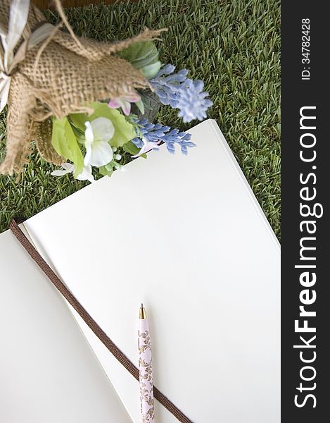 Blank paper page with bouquet flower on green grass