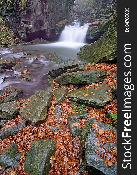 Autumn waterfall in a mountain stream