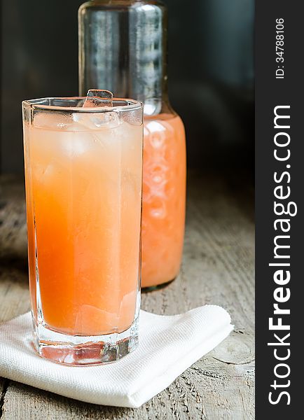 Glass with grapefruit juice and grapefruits