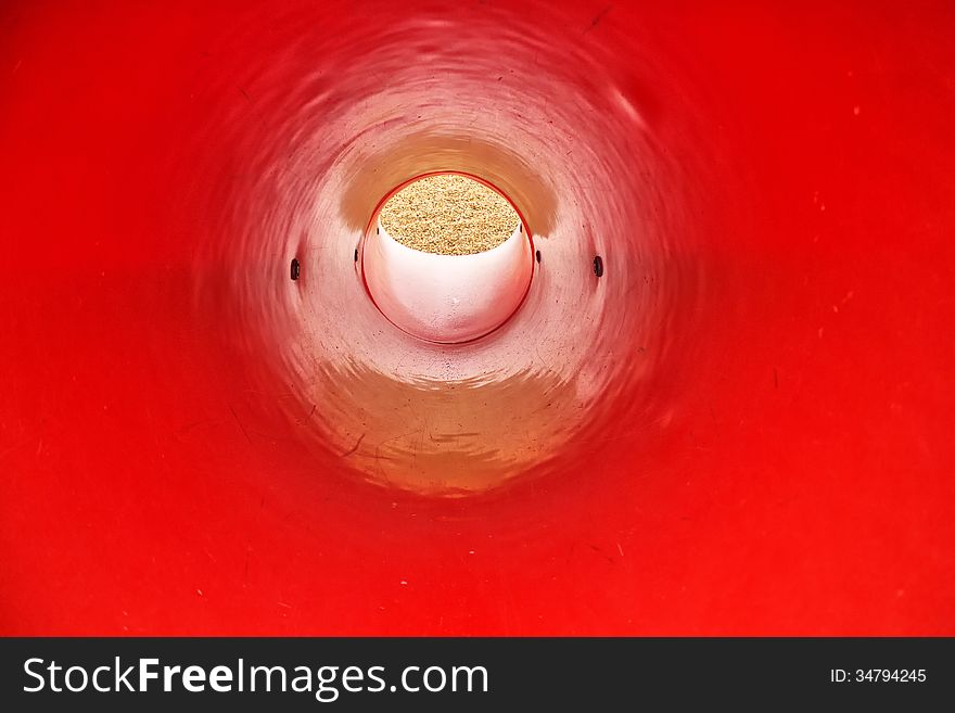 The view inside a red, round, plastic slide. The view inside a red, round, plastic slide