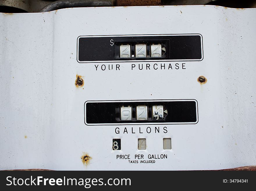 A vintage fuel pump meter on white metal