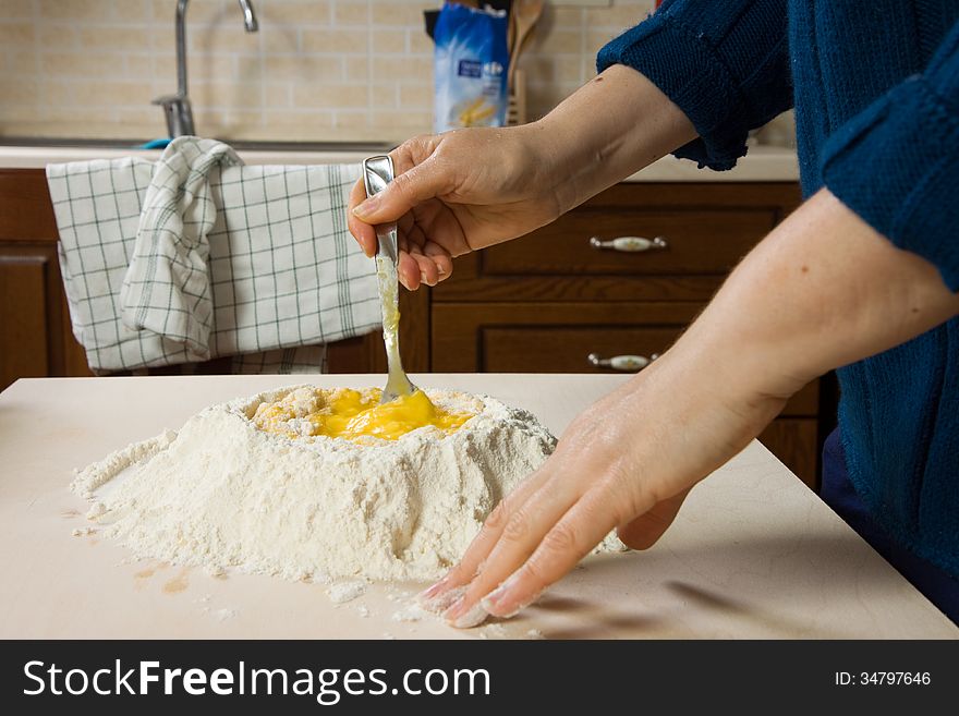 Woman making pasta with eggs and wheat