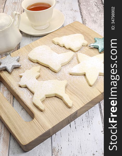 Homemade Christmas shortbread biscuit cookies in reindeer and festive shapes with a cup of tea on vintage blue and white shabby chic table. Homemade Christmas shortbread biscuit cookies in reindeer and festive shapes with a cup of tea on vintage blue and white shabby chic table.