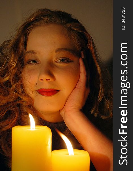 Young beautiful woman by a candle. Young beautiful woman by a candle