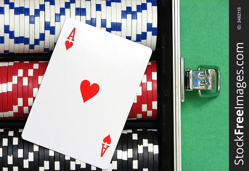 A close up on an ace card over poker chips arranged inside a carrying case. Three rows with white, red and black chips. A close up on an ace card over poker chips arranged inside a carrying case. Three rows with white, red and black chips.