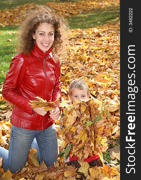 Mother and child among fallen leaves. Mother and child among fallen leaves